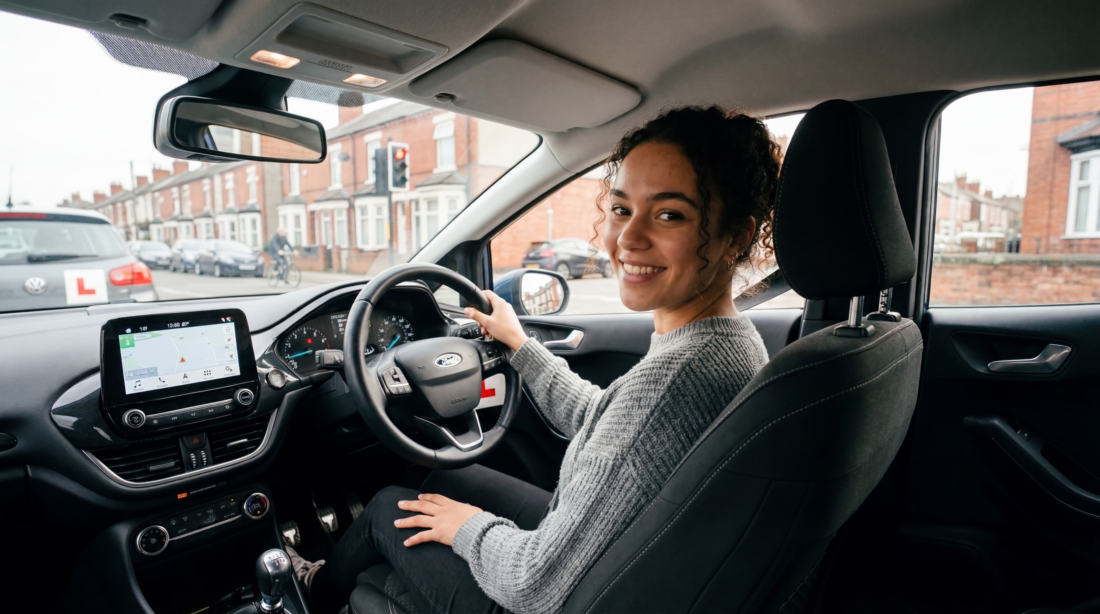 Young learner smiling in the driver's seat of a UK dual-control car